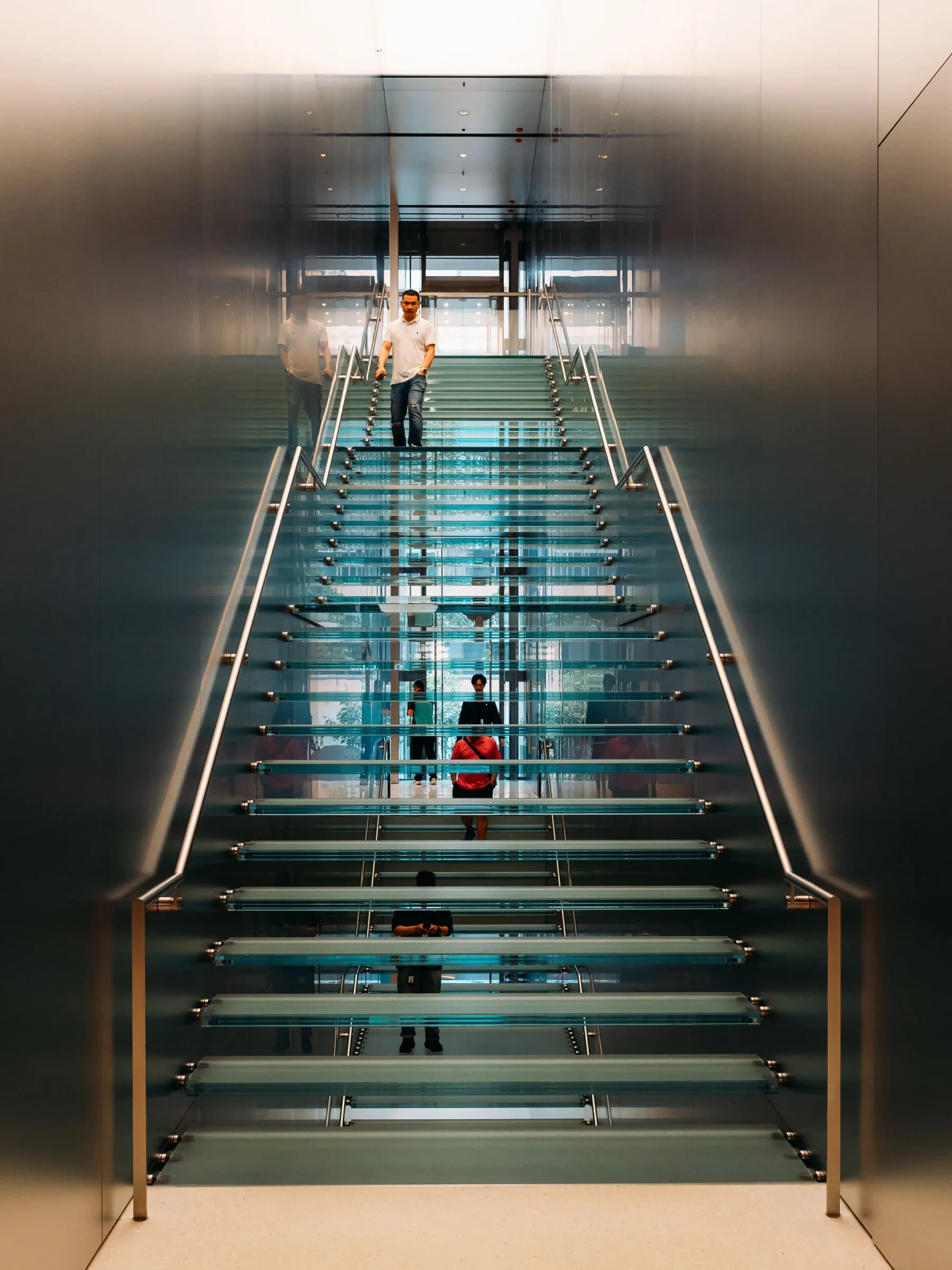 Escalera de vidrio iluminada en un interior corporativo