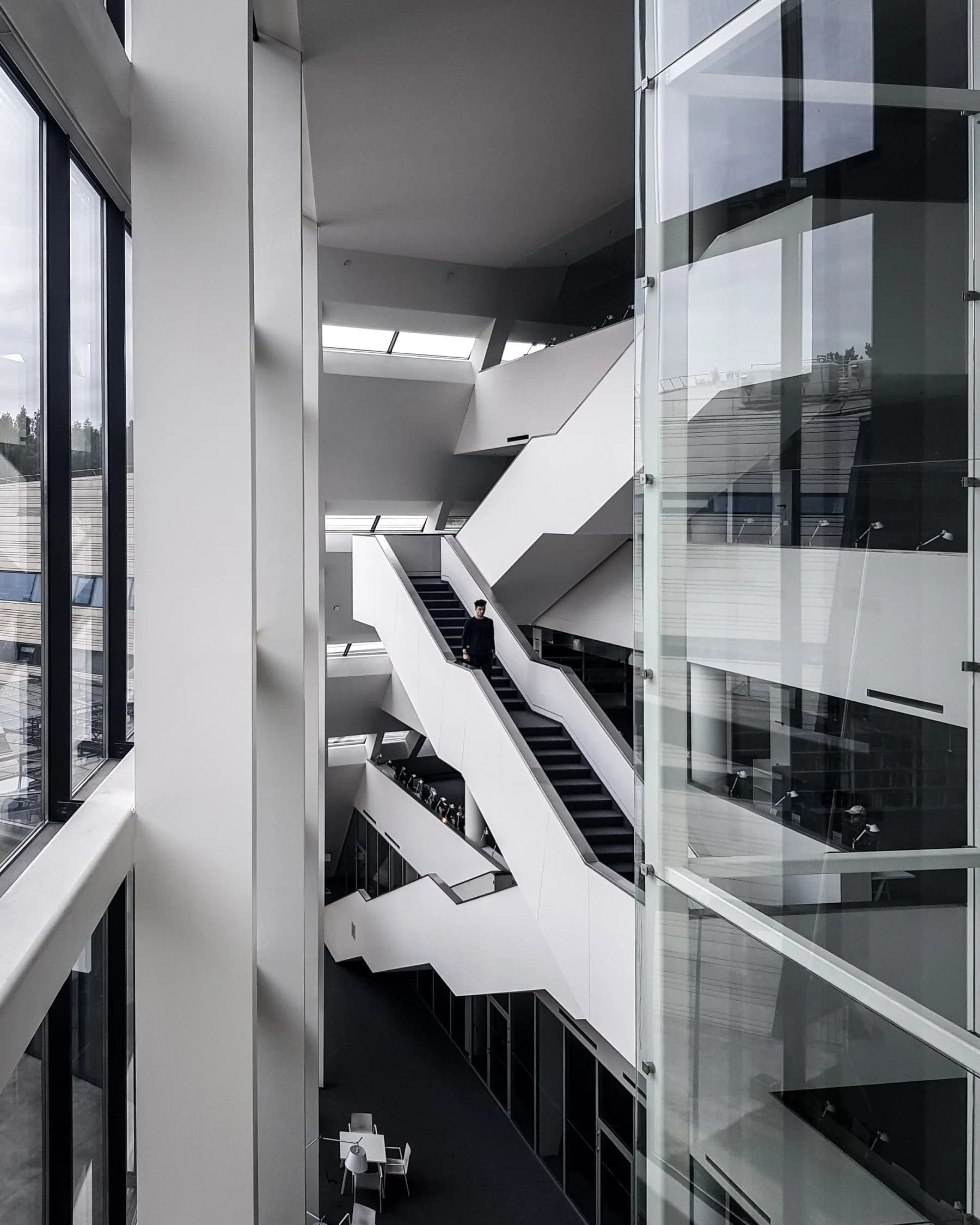 Escaleras geométricas en un atrio corporativo en blanco y negro