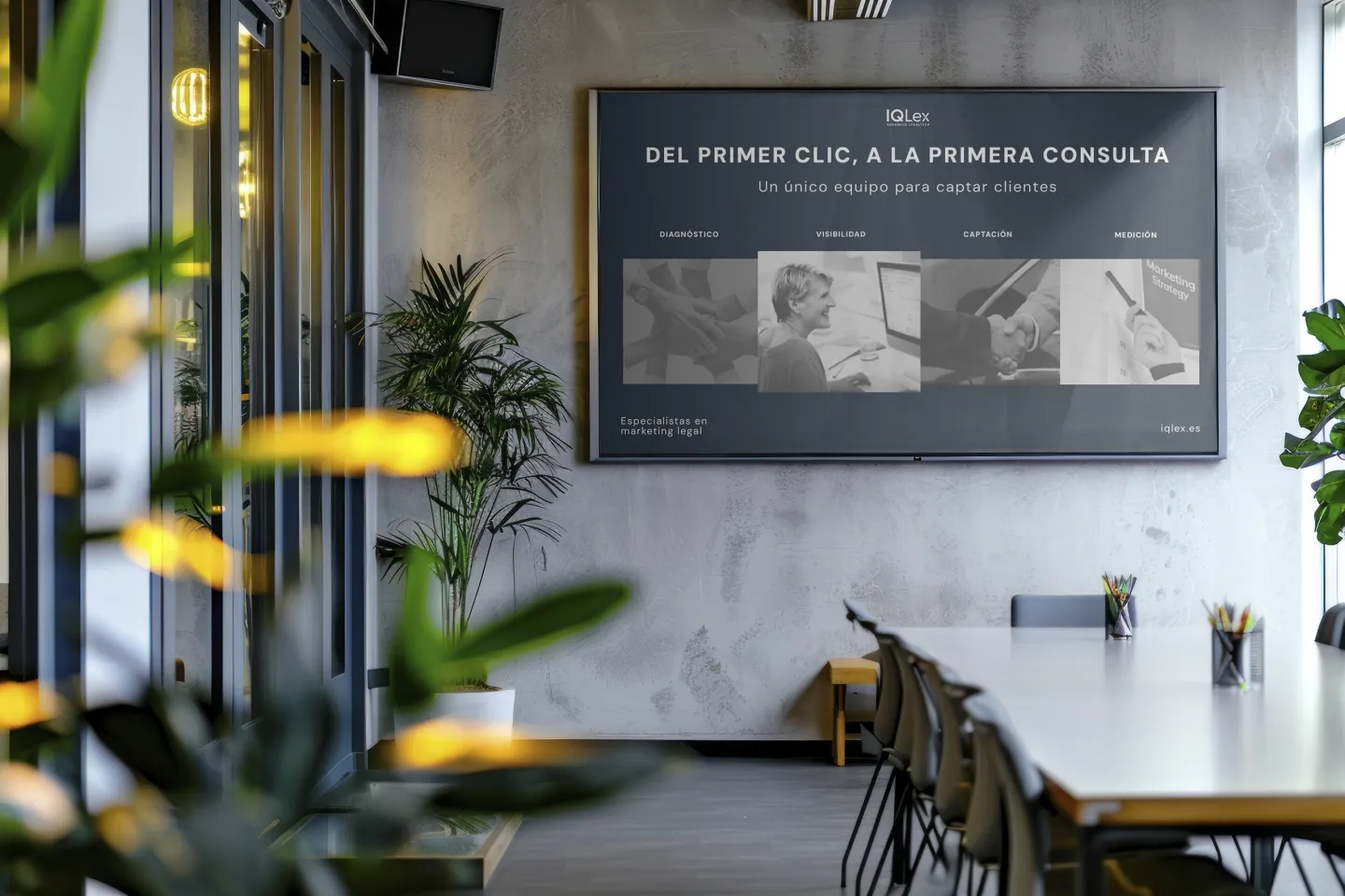 Sala de reuniones con una pantalla de IQLex: «Del primer clic a la primera consulta», con las fases diagnóstico, visibilidad, captación y medición